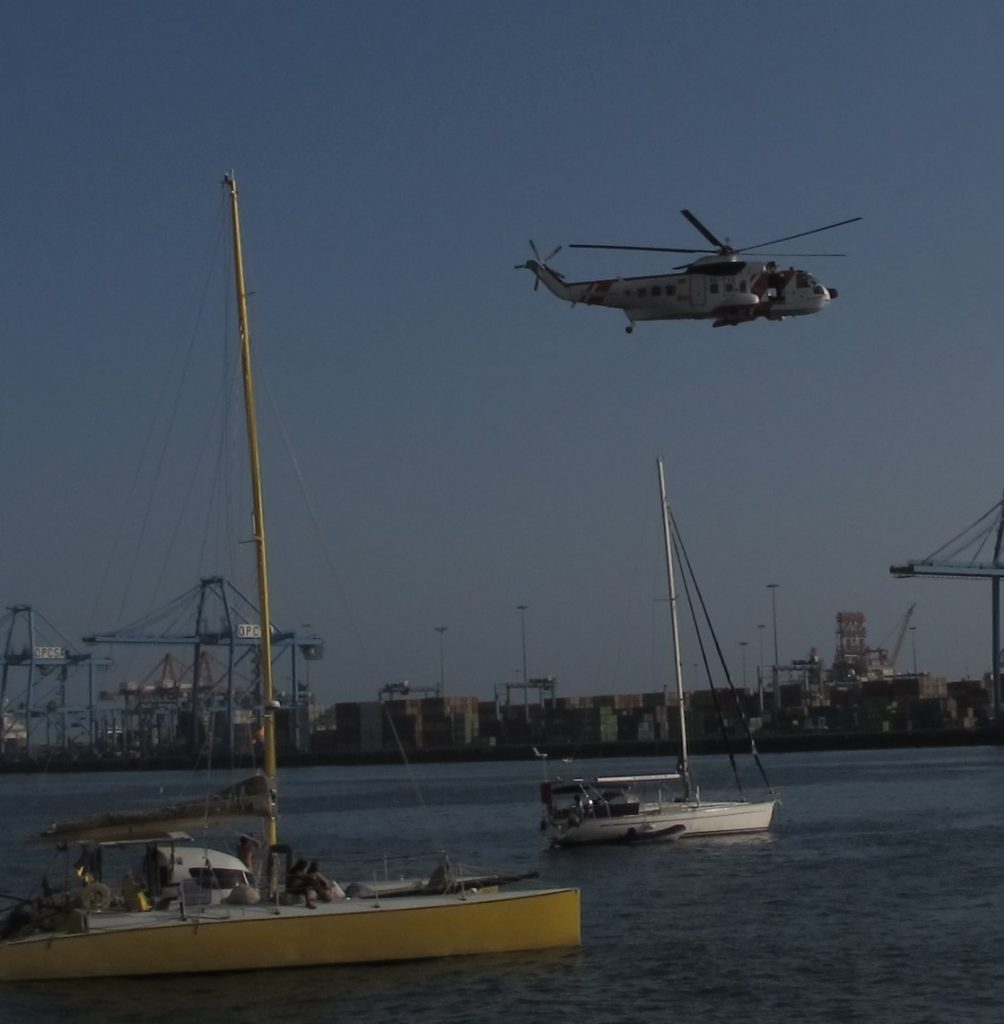 Helikopteret skal redde en på den hvite båten i bakgrunnen.